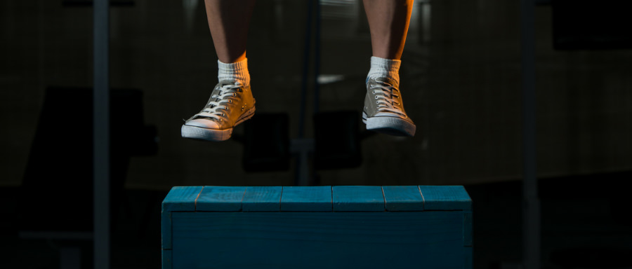 A person doing plyometrics wearing Converse low-top sneakers