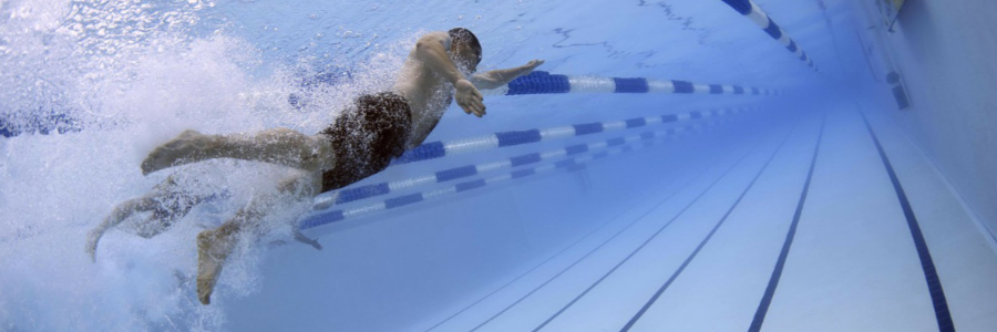 An underwater photograph of multiple swimmers swimming in a lap pool