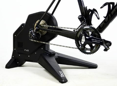 A photograph of a Tacx Flux Smart Direct-Drive cycling trainer with a Colnago bike attached