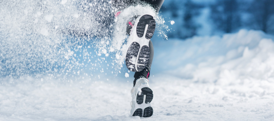 A photograph of an athlete running outdoors in the snow