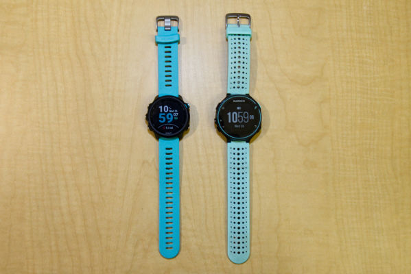 The new Garmin Forerunner 245 Music with Aqua band next to the Forerunner 235 on a wooden surface