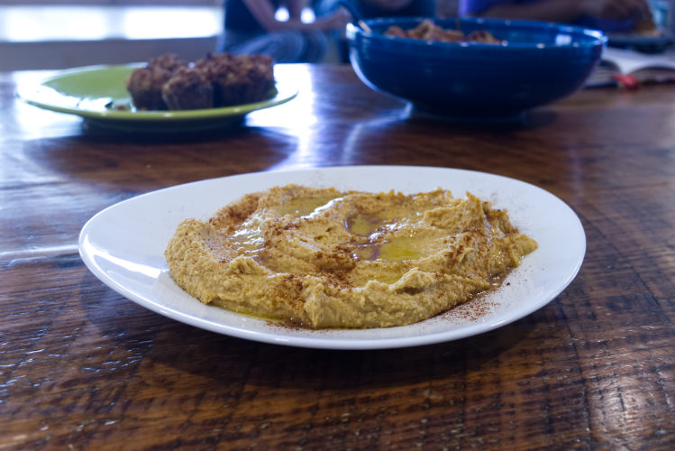 A plate of sweet potato hummus on a wooden counter