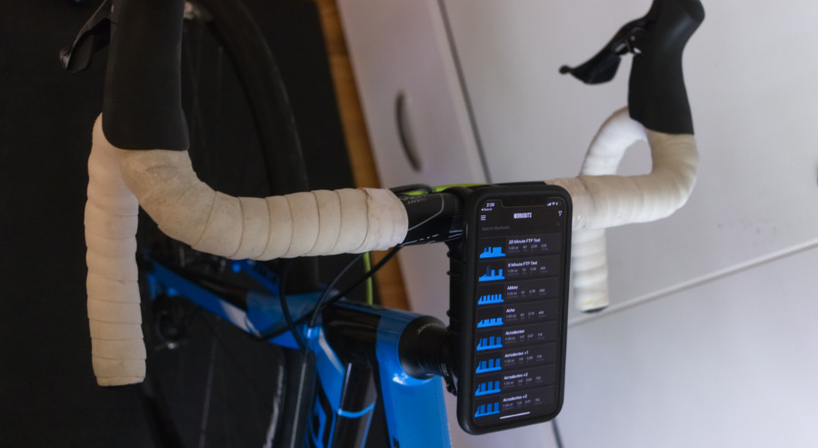 The TrainerRoad app running on an iPhone 11 mounted to a road bike for indoor cycling