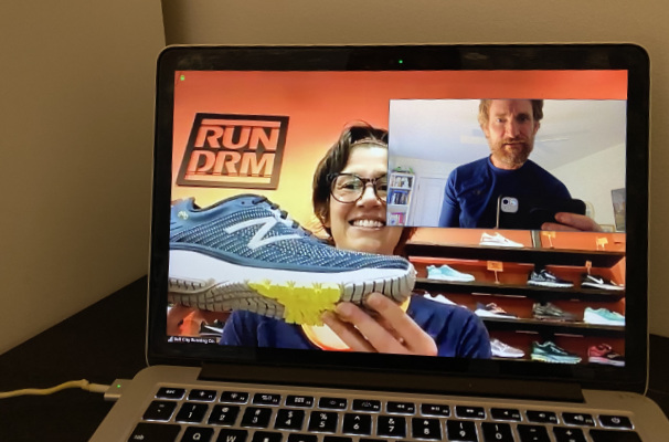 A photograph of a laptop with a Zoom call between a running shoe expert and a client