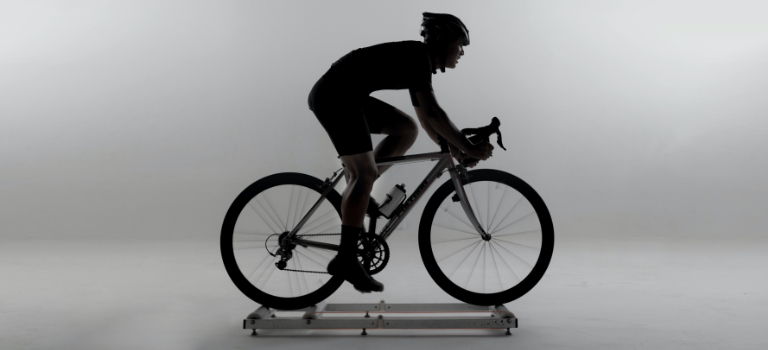 A road cyclist rides on indoor rollers 